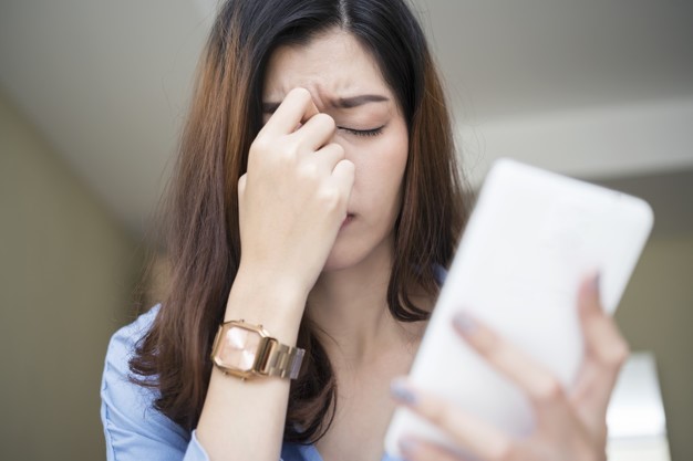 Woman using smartphone and feeling fatigue and headache. Premium Photo